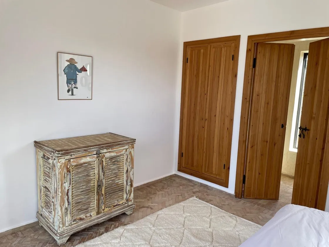 Chambre aux teintes miel avec soleil tressé et kilim ocre