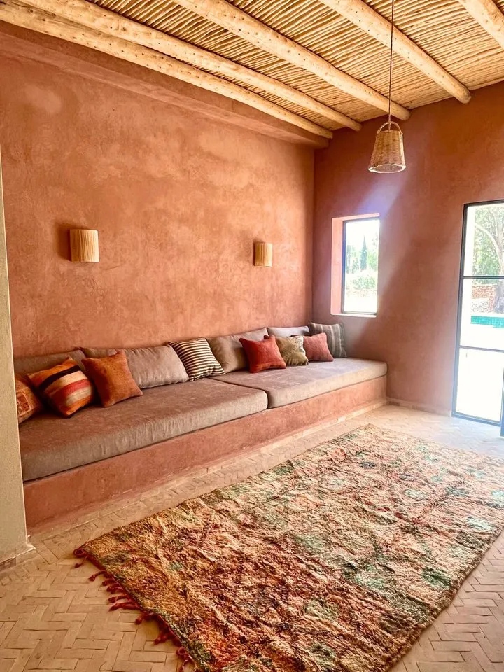 Grande pièce de vie aux banquettes maçonnées et tapis berbères